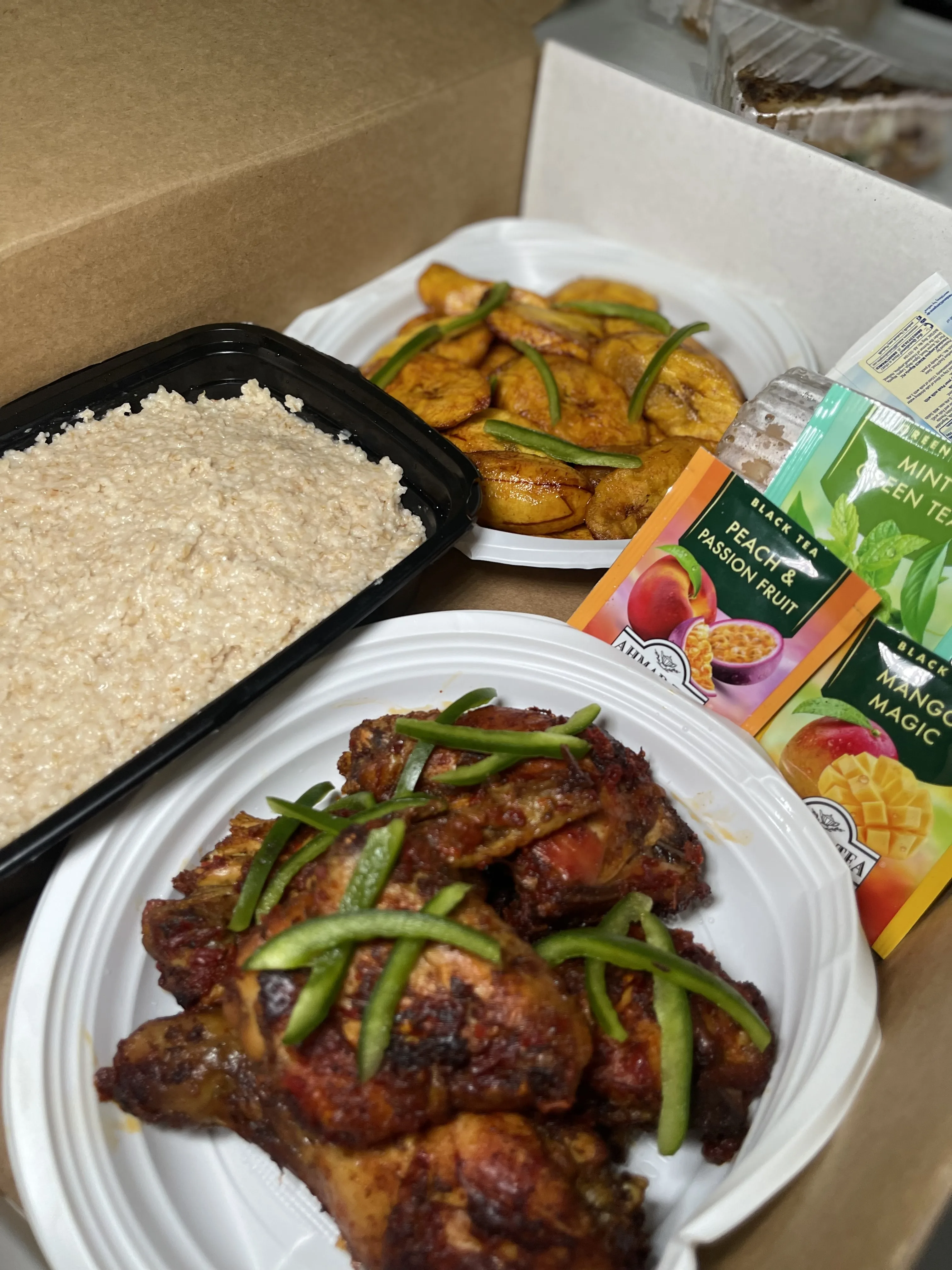 Food delivery box with rice, plantain, and peppered chicken